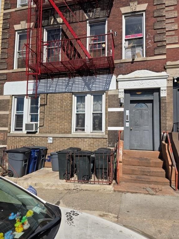 property entrance featuring cooling unit and brick siding