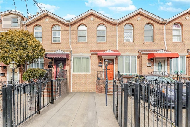 view of property featuring a fenced front yard and brick siding