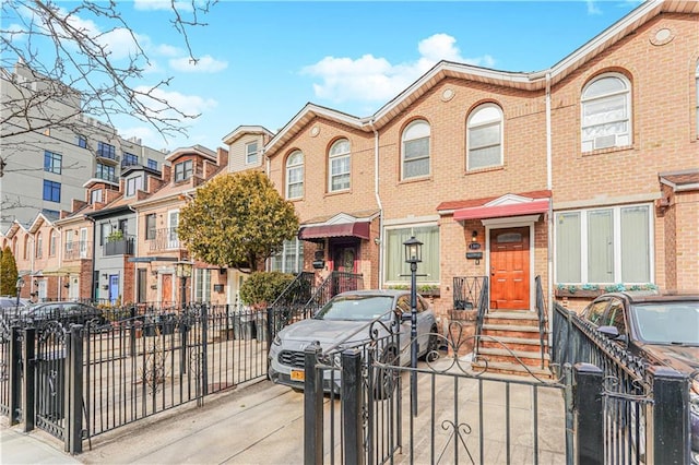 multi unit property featuring entry steps, brick siding, and fence