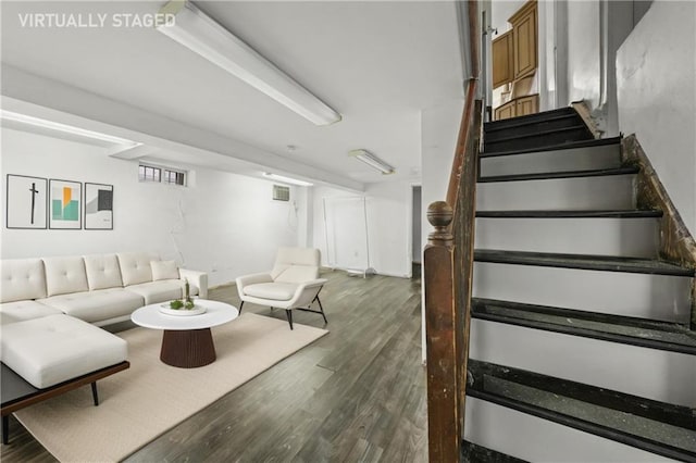 living area featuring visible vents, stairway, and dark wood-type flooring