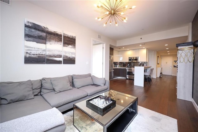 living room featuring an inviting chandelier, visible vents, dark wood-style flooring, and recessed lighting