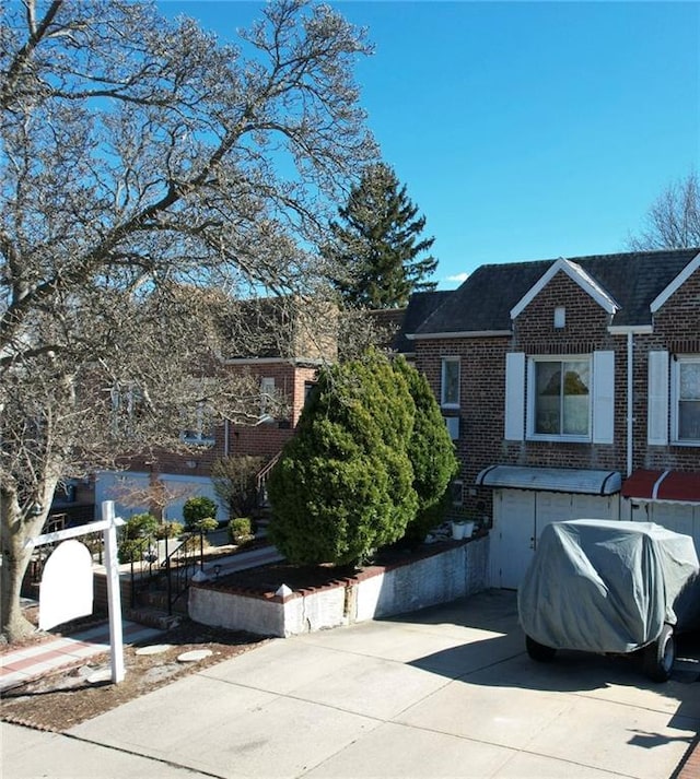 view of front facade with brick siding and concrete driveway