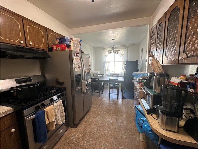 kitchen featuring dark brown cabinetry, stainless steel gas range oven, an inviting chandelier, light countertops, and under cabinet range hood