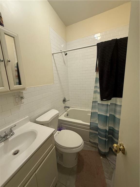 full bathroom with shower / tub combo, vanity, toilet, and tile walls