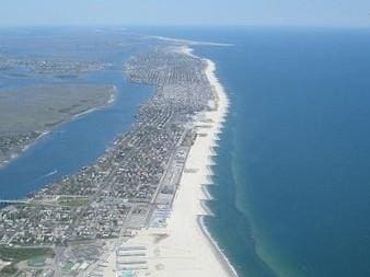 drone / aerial view featuring a water view and a view of the beach