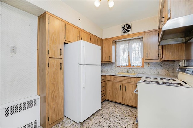 kitchen with radiator, visible vents, a sink, white appliances, and under cabinet range hood