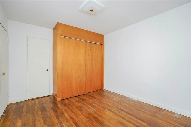 unfurnished bedroom featuring a closet and wood finished floors