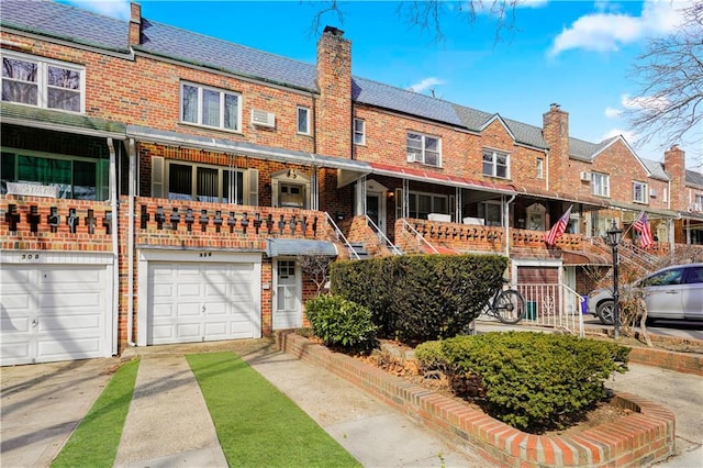 multi unit property with concrete driveway, brick siding, and a chimney