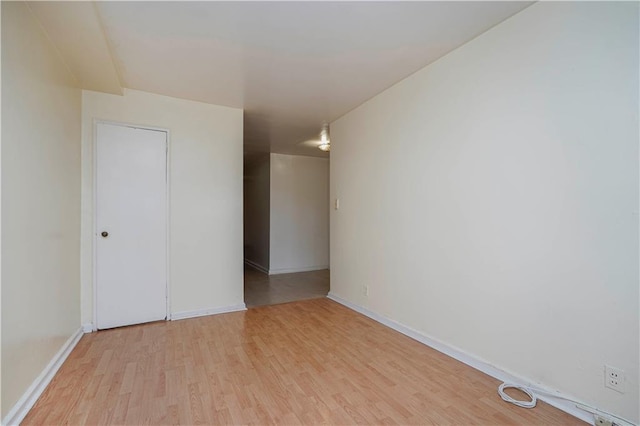 spare room with light wood-type flooring and baseboards