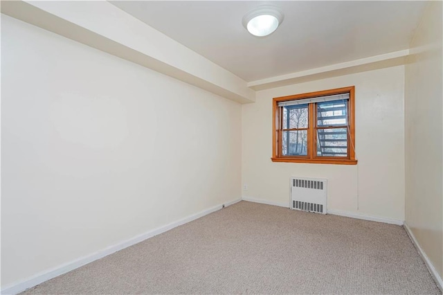 carpeted spare room with radiator heating unit and baseboards