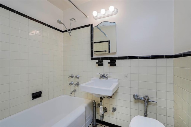 full bathroom featuring toilet, shower / bath combination, a sink, and tile walls