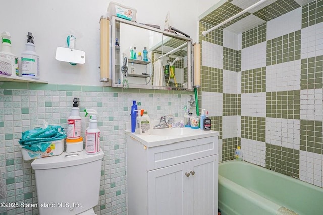 bathroom with shower / tub combination, tile walls, toilet, and vanity