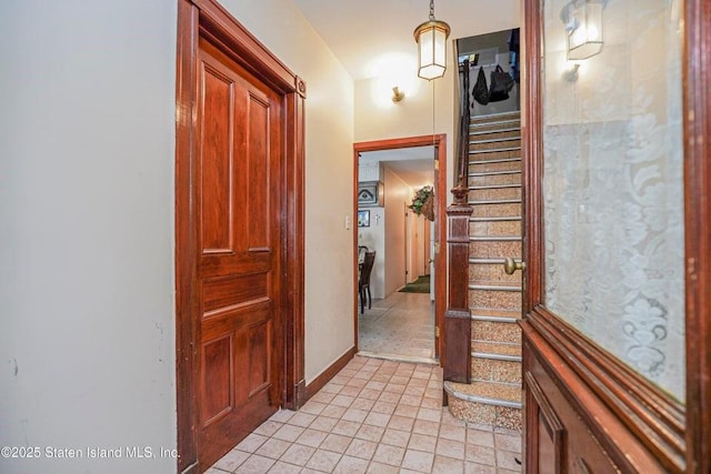 hallway with baseboards and stairs