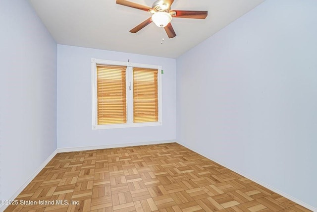 spare room featuring a ceiling fan and baseboards