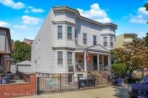31 Seeley St, Brooklyn, NY 11218 - townhome / multi-family property with a fenced front yard and a porch