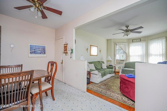 dining space featuring cooling unit, ceiling fan, and light floors