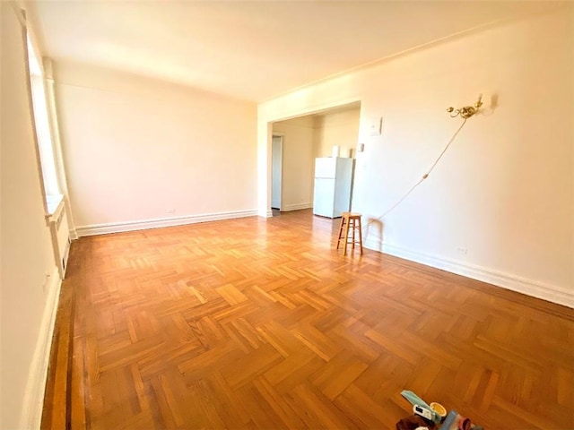 unfurnished room with baseboards