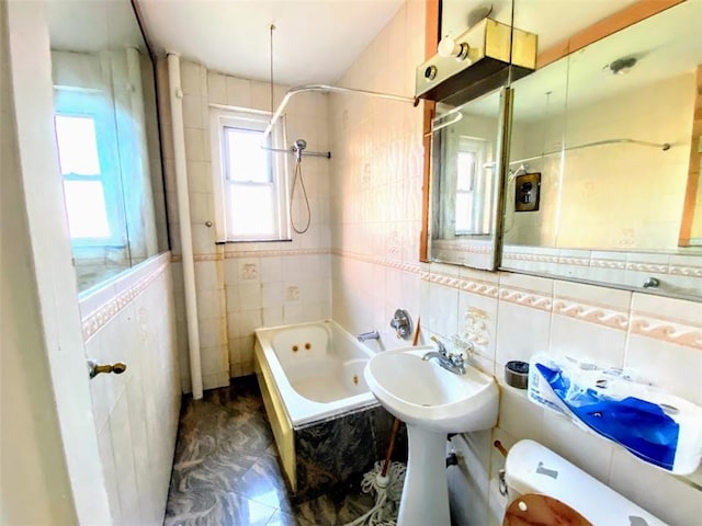 full bath featuring a combined bath / shower with jetted tub, a sink, tile walls, and toilet