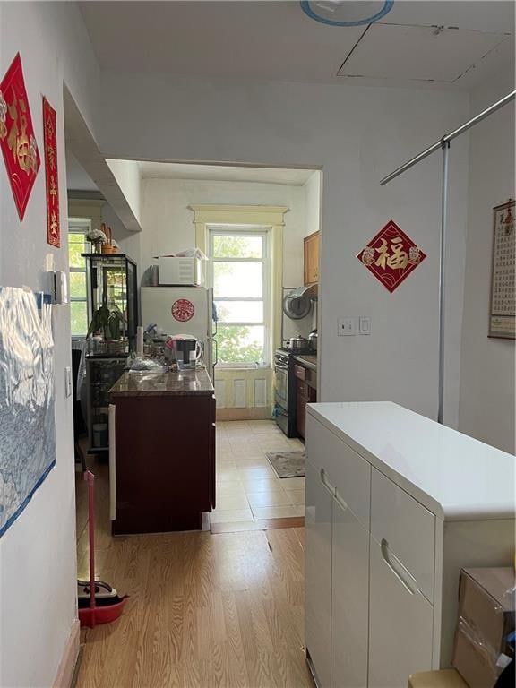 kitchen with a kitchen island, light wood-style floors, and range