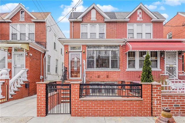 view of front facade with a fenced front yard and brick siding