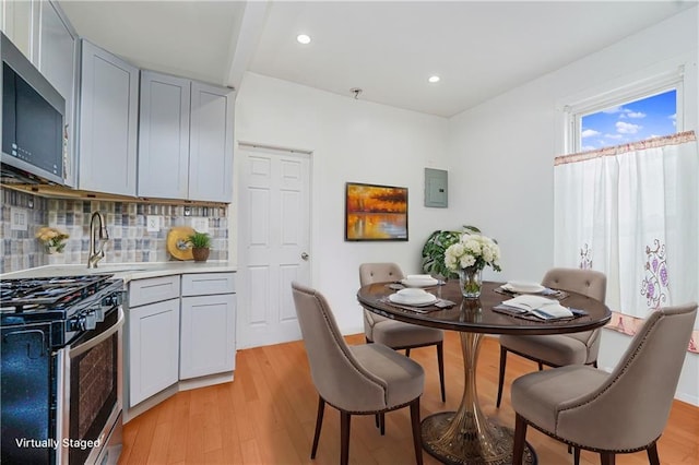 dining room with electric panel, recessed lighting, and light wood-style flooring