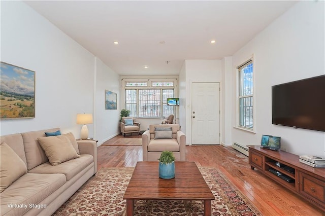 living area with recessed lighting, a baseboard radiator, and light wood finished floors