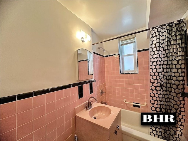 full bathroom featuring washtub / shower combination, wainscoting, tile walls, and vanity