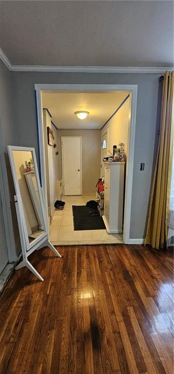 hallway with ornamental molding and hardwood / wood-style floors