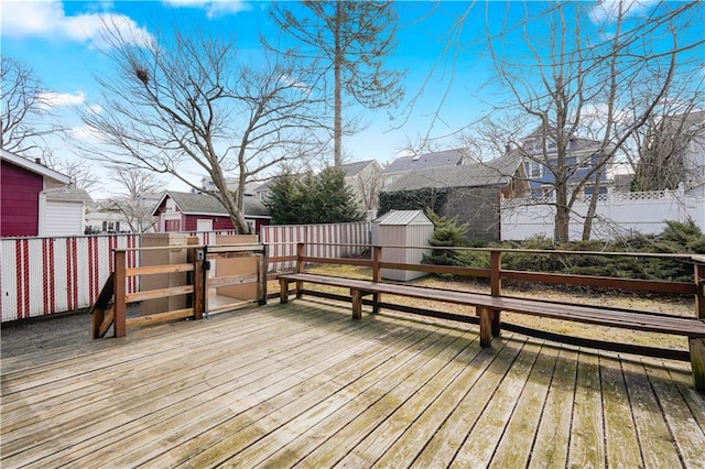 deck with an outbuilding, a residential view, and a storage unit