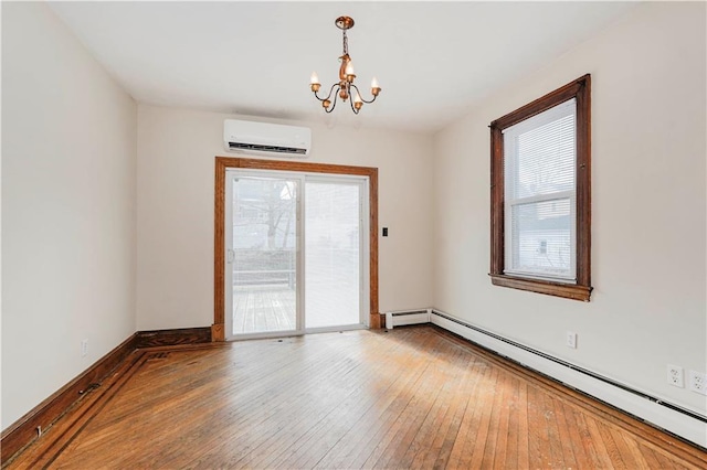 empty room featuring wood-type flooring, baseboard heating, a wealth of natural light, and a wall mounted air conditioner