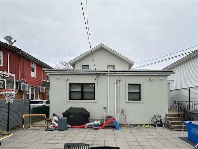 rear view of property with ac unit, a patio area, fence, and stucco siding