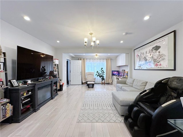 living room featuring light wood-style floors, recessed lighting, and a notable chandelier