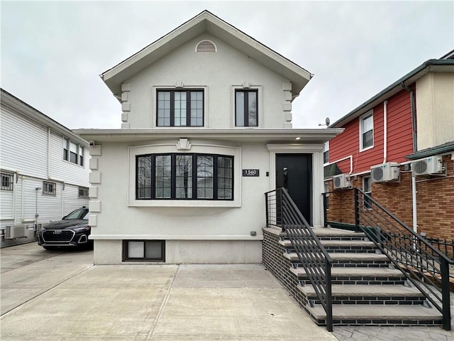 view of front of home featuring a wall mounted AC and stucco siding