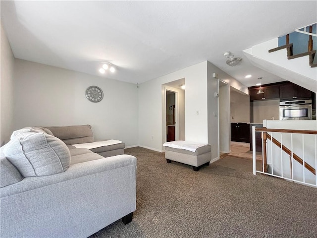 carpeted living area featuring stairway and baseboards