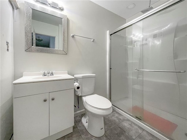 bathroom featuring a stall shower, tile patterned flooring, vanity, and toilet