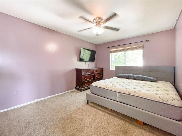 bedroom featuring ceiling fan, baseboards, and light colored carpet