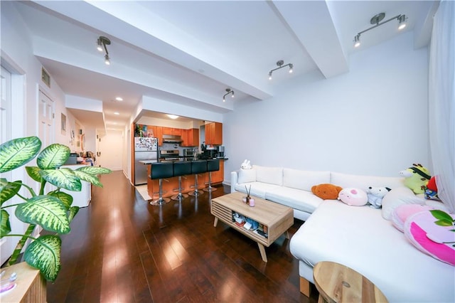 living room featuring beamed ceiling, visible vents, hardwood / wood-style floors, and rail lighting