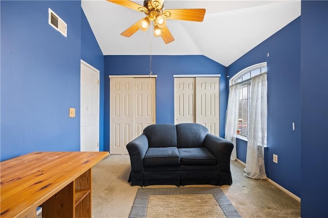 living area featuring carpet floors, visible vents, baseboards, vaulted ceiling, and a ceiling fan