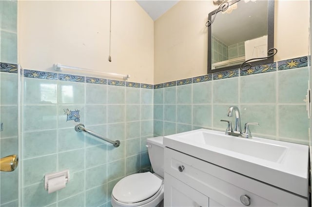 bathroom featuring toilet, tile walls, and vanity