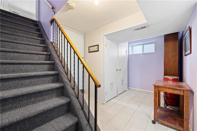 stairs with visible vents, baseboards, and tile patterned floors