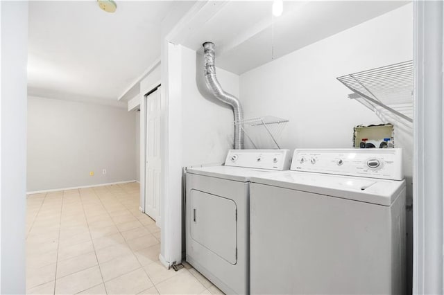 laundry area with laundry area, baseboards, washer and clothes dryer, and light tile patterned flooring