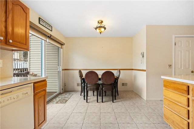 interior space with visible vents, dishwasher, brown cabinets, light countertops, and light tile patterned flooring