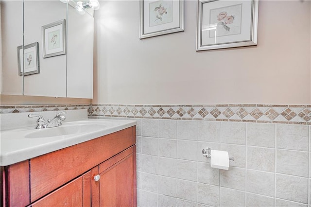 bathroom with tile walls, a wainscoted wall, and vanity