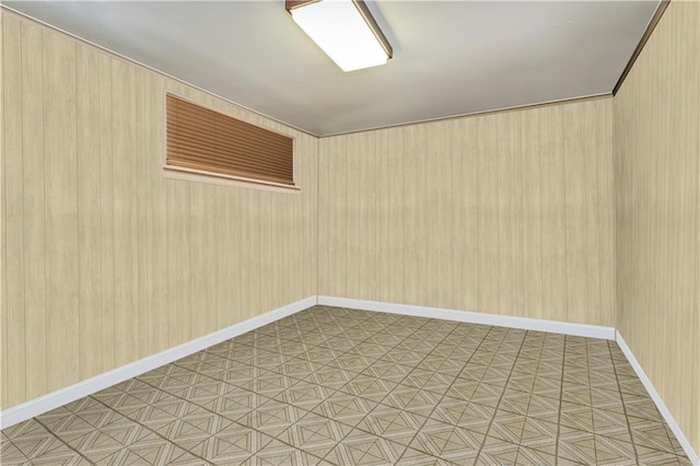 spare room with wooden walls and baseboards