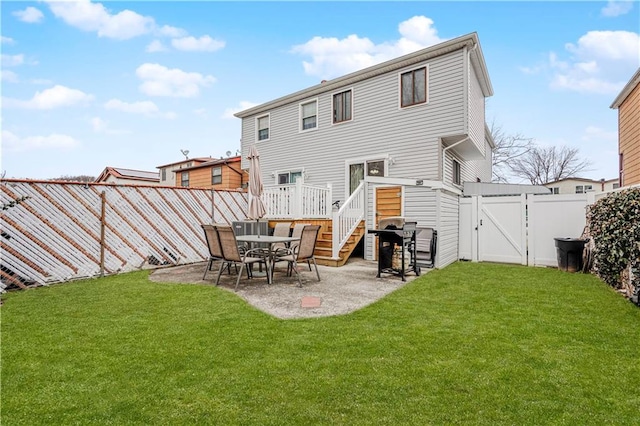 rear view of property with a yard, a patio area, a fenced backyard, and a gate