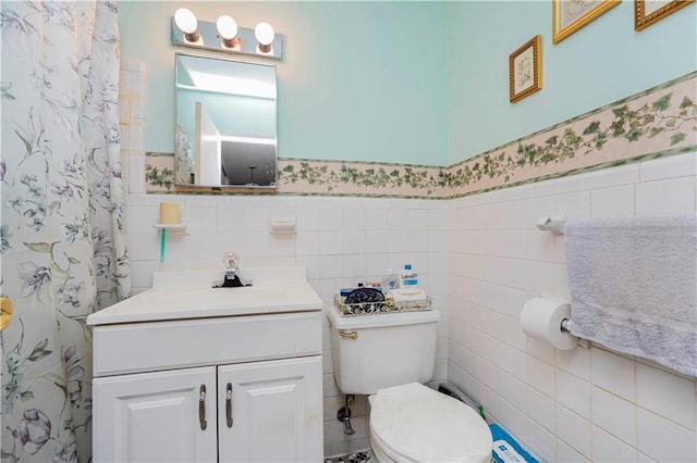 full bath with a wainscoted wall, vanity, toilet, and wallpapered walls