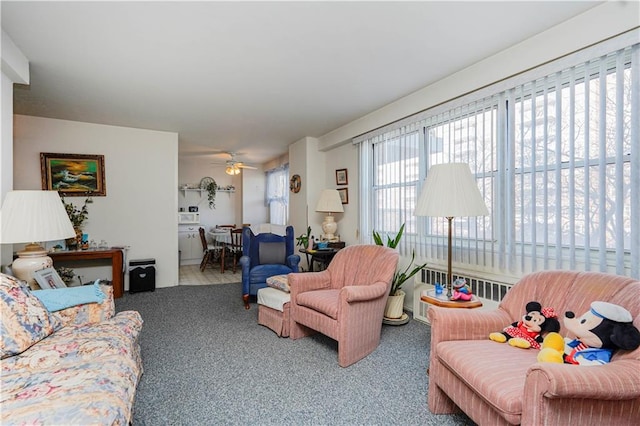 living area with radiator, a ceiling fan, and carpet flooring