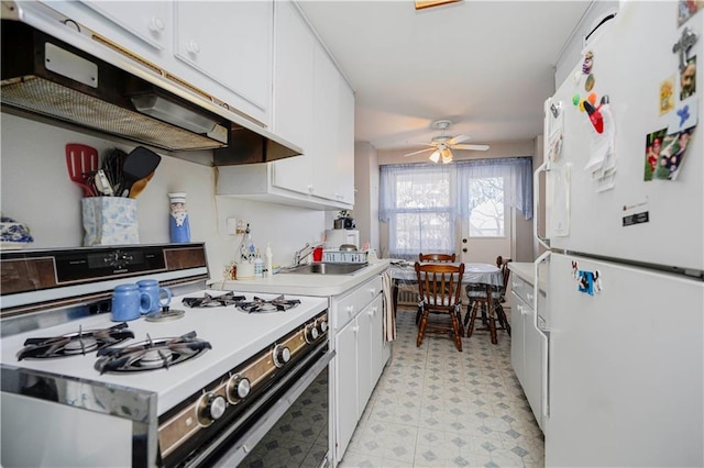 kitchen featuring white appliances, a sink, white cabinets, light countertops, and light floors