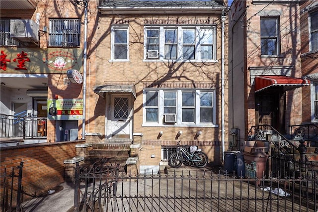 townhome / multi-family property featuring brick siding and fence