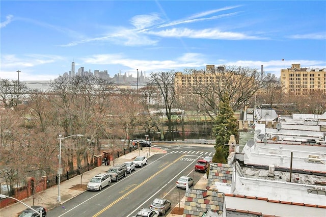 exterior space with sidewalks, street lighting, a view of city, and curbs